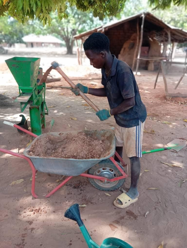 Joven de la aldea trabajando con la máquina de bloques